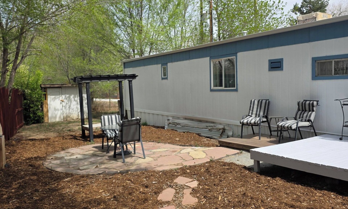 Longmont House | Spacious mobile home with large kitchen/living area and porch with barbeque.